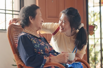 Older asian woman visits with granddaughter