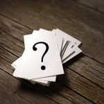 Card with a question mark on it resting on a pile of other cards