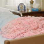 blanket on the end of an empty hospital bed