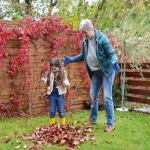 Grandmother and her grandchild playing with leaves