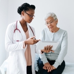 young black female doctor with older adult